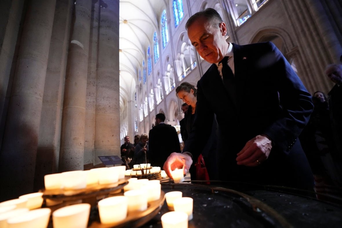 A man lights a candle in Notre-Dame Cathedral in Paris