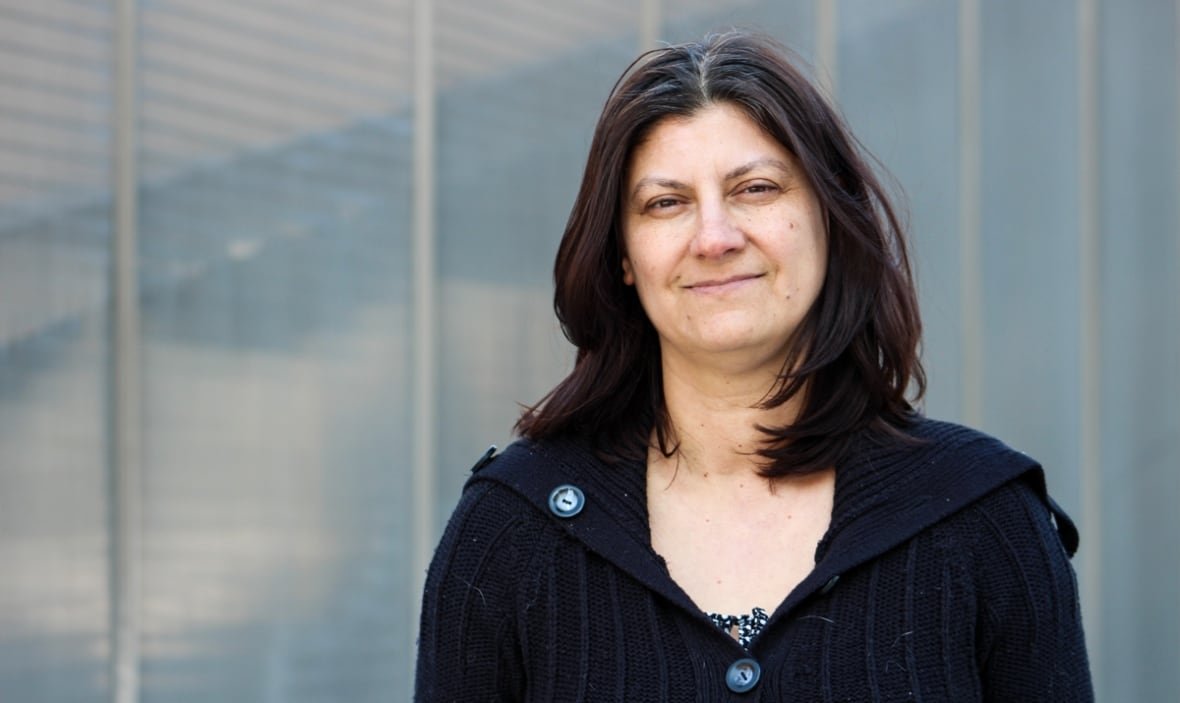 A woman in a sweater standing outside.