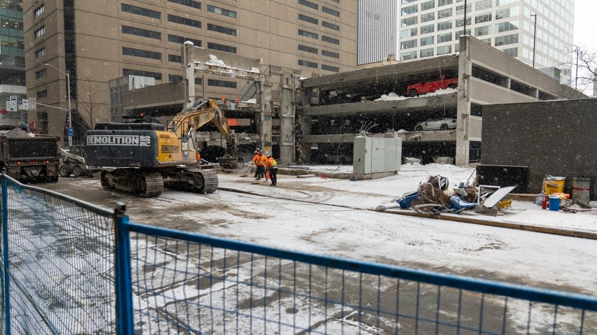 An urban construction site is seen on a snowy winter day.