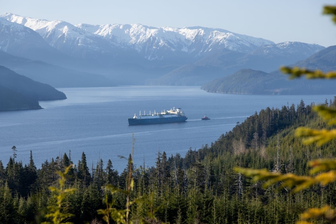 A distant shop of a freight ship pulled by a tugboat.
