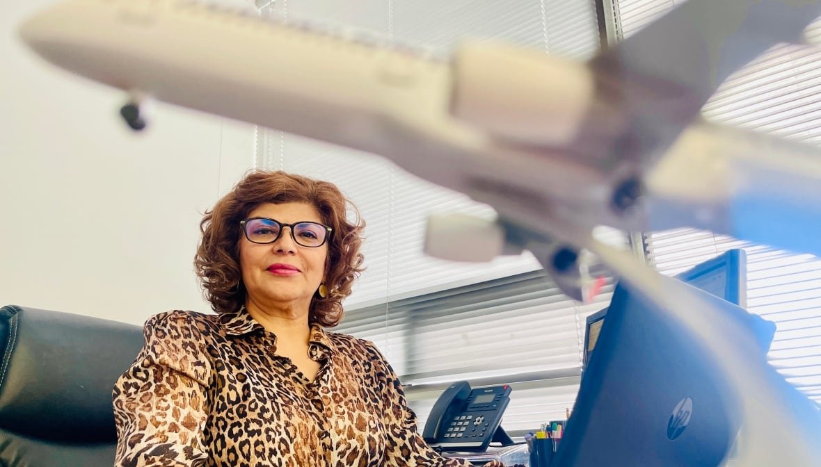 Azin Mohager sitting at a desk at Atlas Travel.