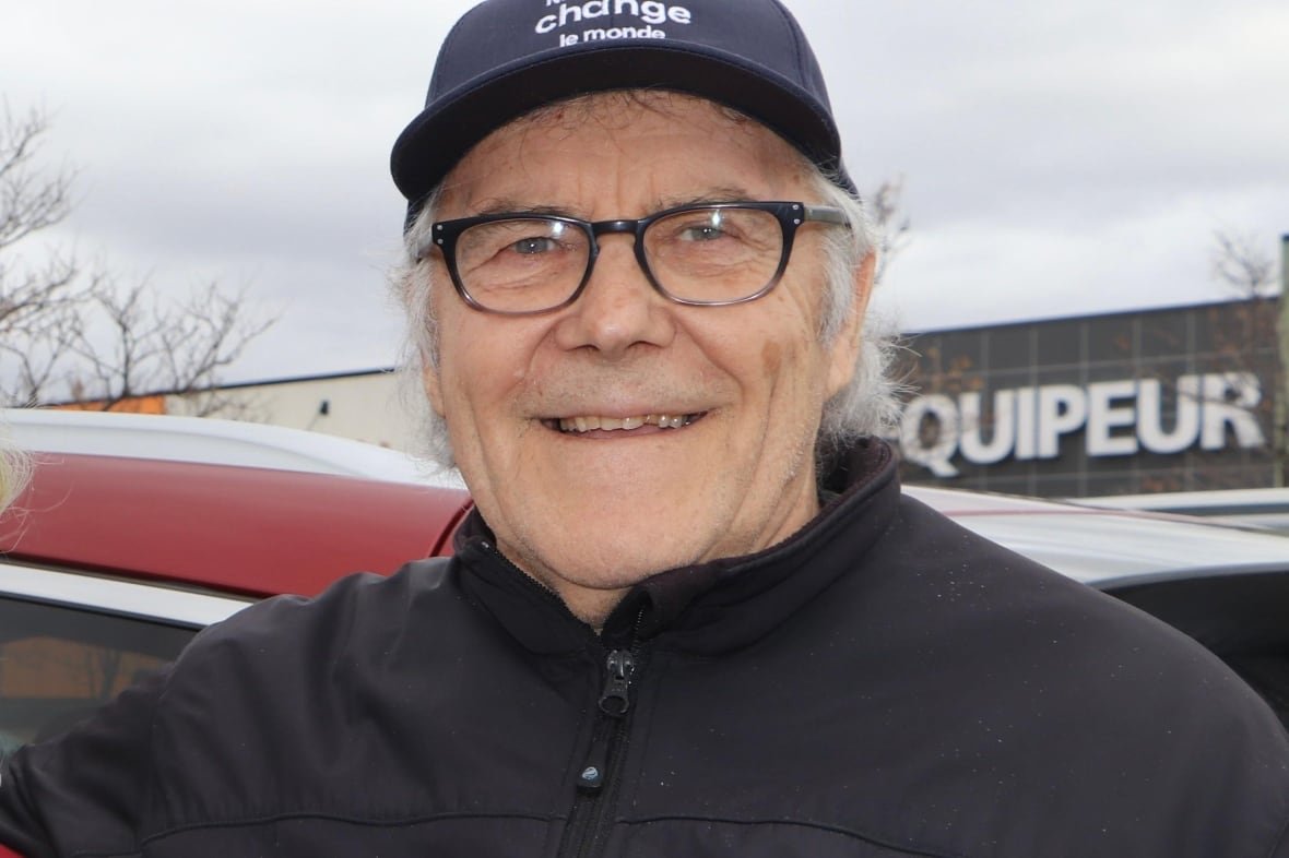 A man wearing a baseball cap smiling. 