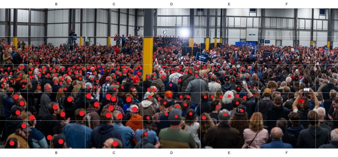A crowd of people watch a politician speak.