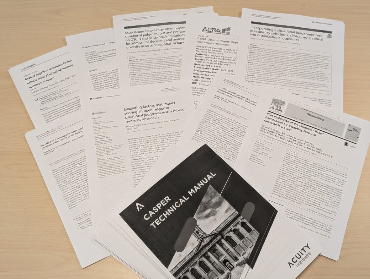 Black-and-white print-outs of scientific research laid out on a table.