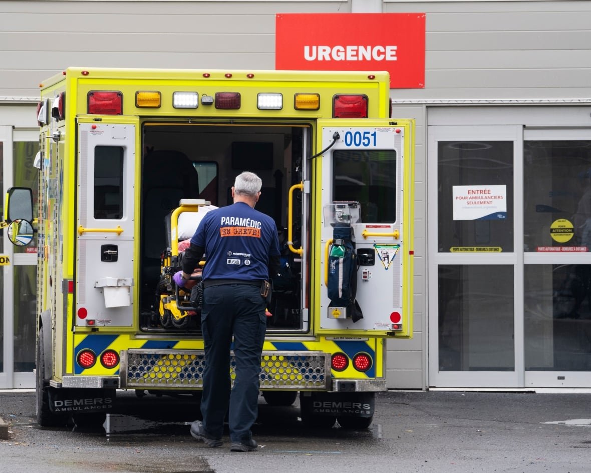 A paramedic loads his stretcher back into the ambulance.