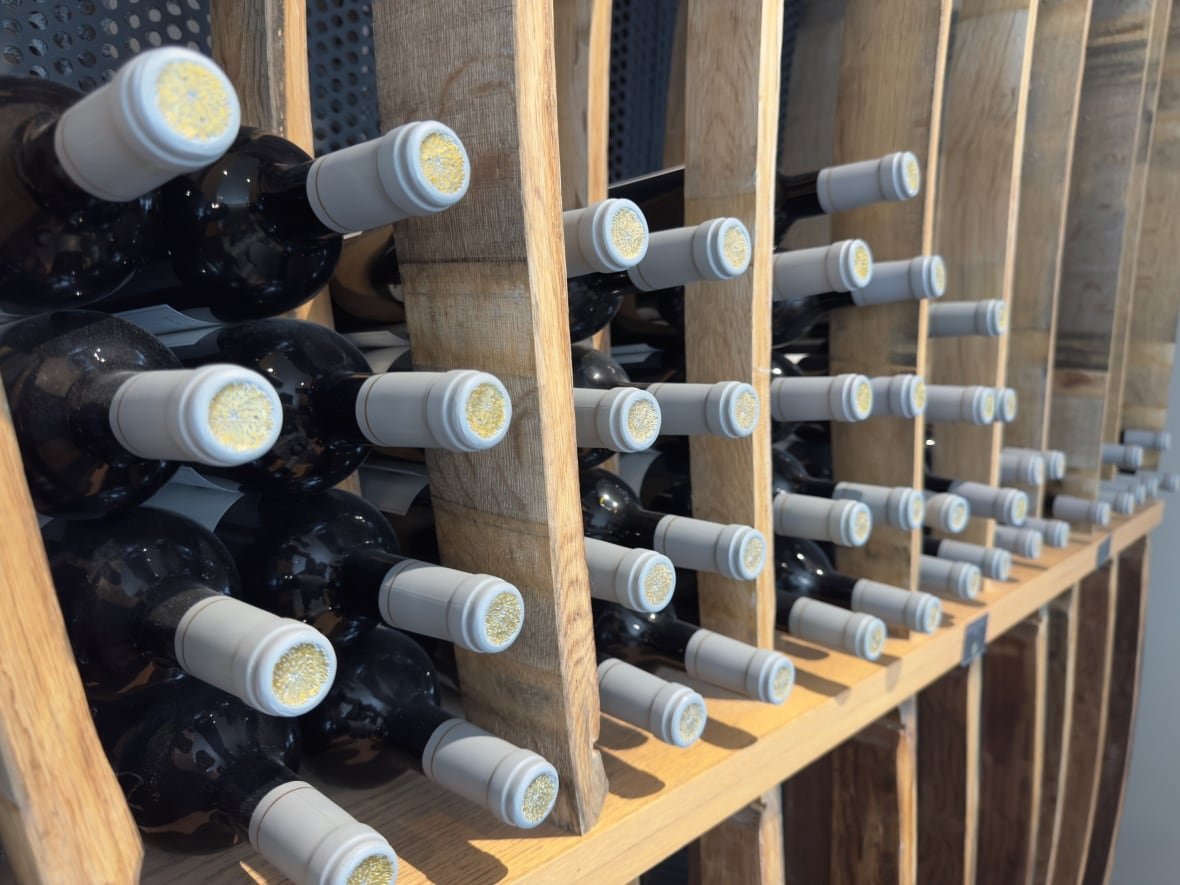 Bottles of wine are stacked on a store shelf.