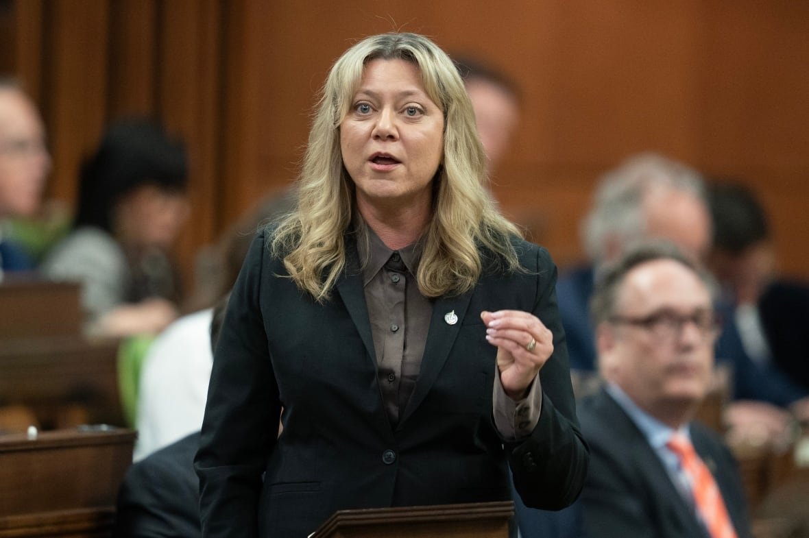 A woman gestures with her hand as she speaks in the House of Commons.