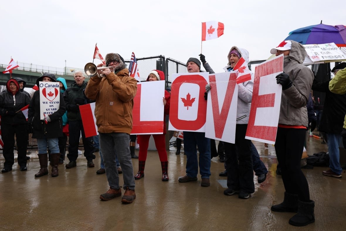 People hold up maple leaves and the word 'LOVE'