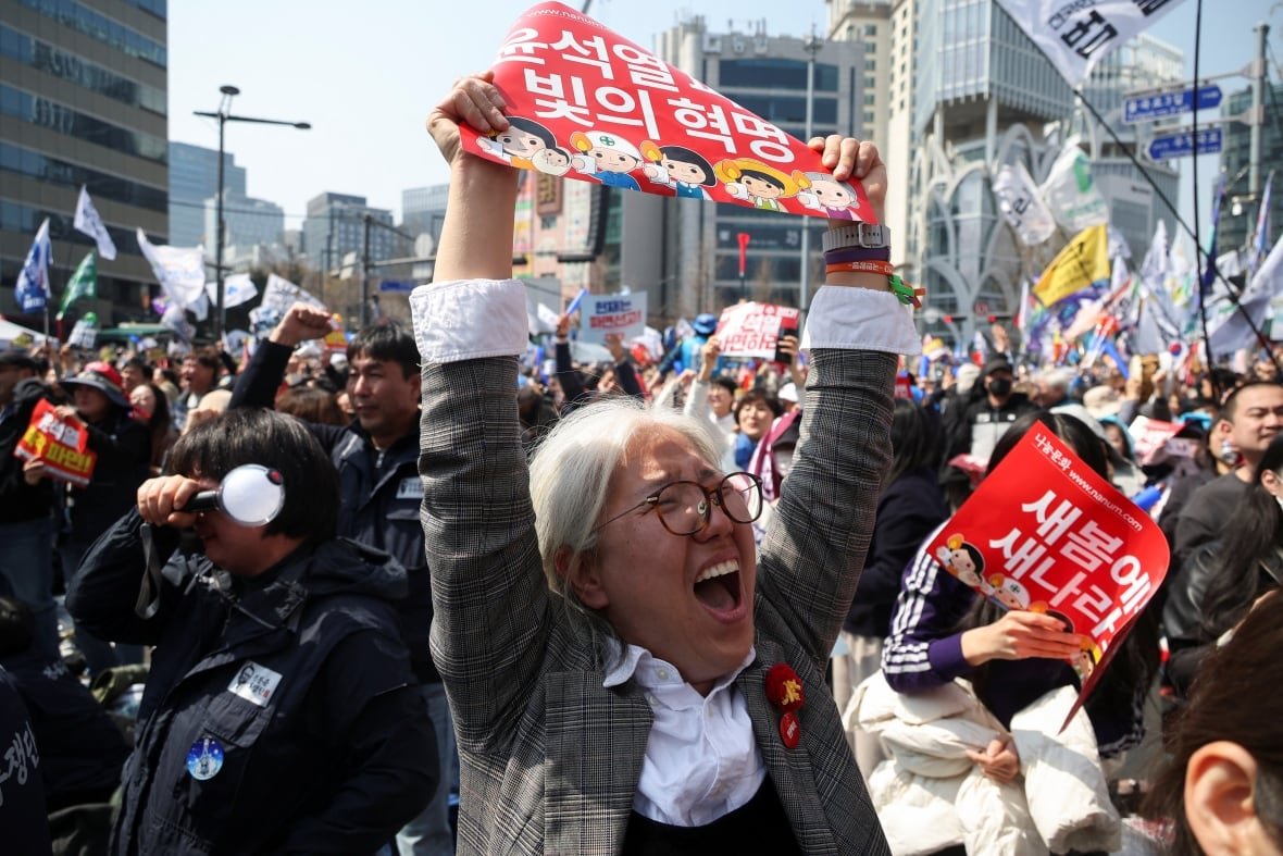 People celebrate during an outdoor rally.