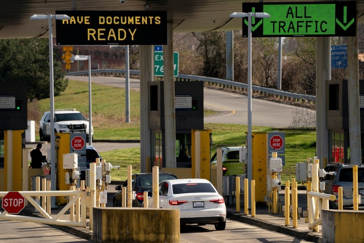 Vehicles are shown at a toll or border point.