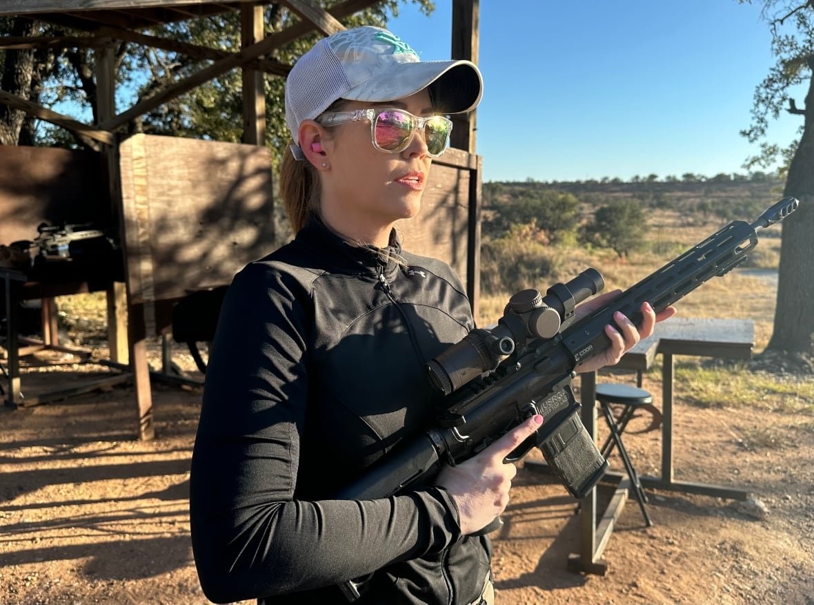 Private investigator Becca, whose last name we are protecting, stands holding a gun at a shooting range.