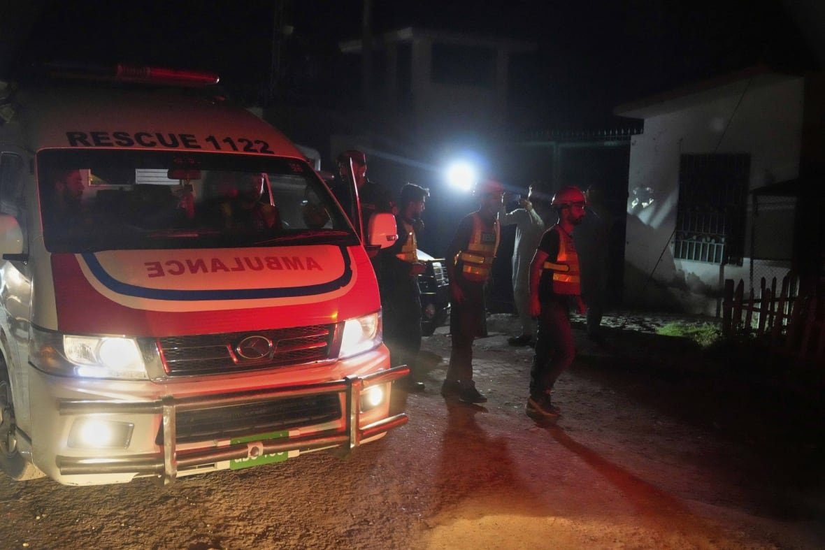 Rescue workers are seen near an ambulance that arrived Wednesday at the site of a suspected Indian missile attack in Muridke, Pakistan.