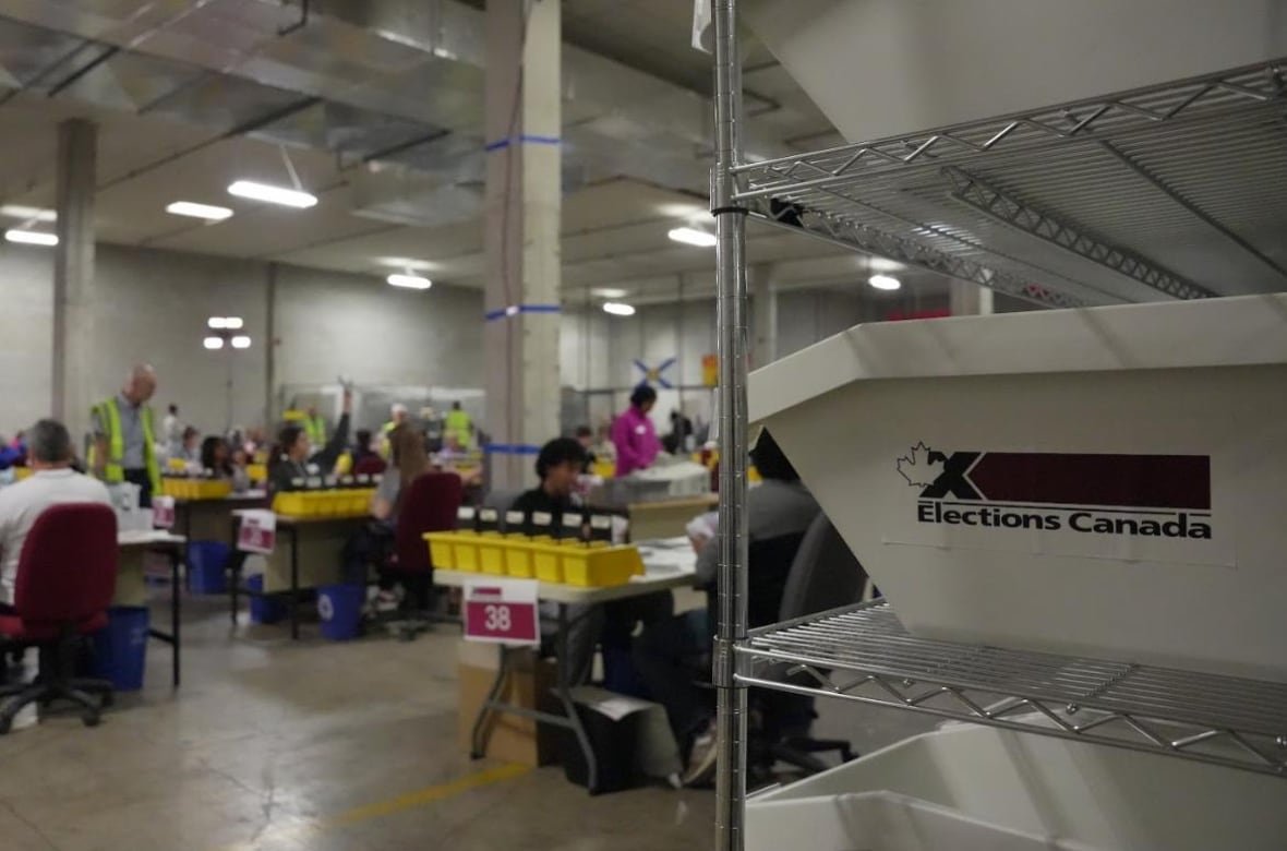 People sit at desks with yellow sorting bins.