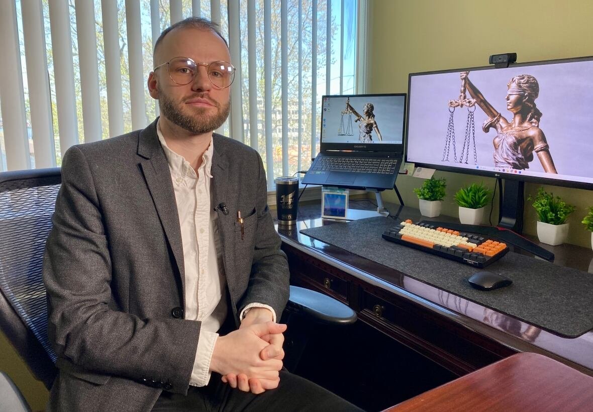 Man in a suit sitting at his desk.
