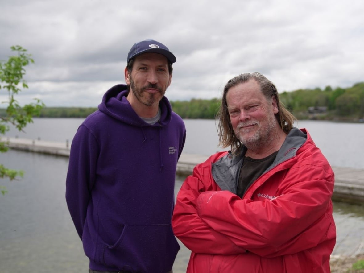 Two men stand near a lake in eastern Ontario.