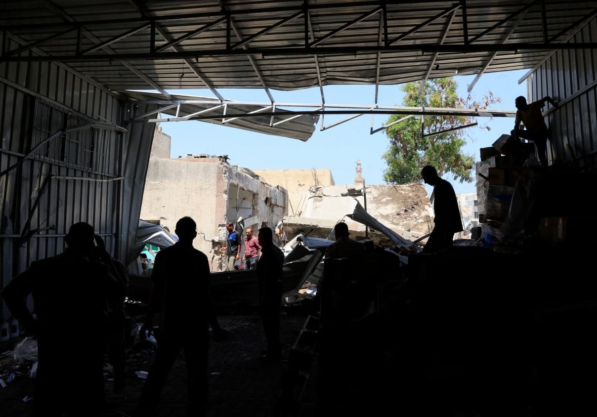 Palestinian staff members inspect the medicine warehouse in Nasser Hospital after an Israeli strike.