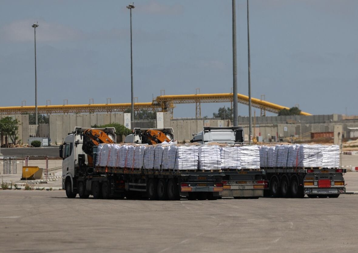 Trucks carrying aid enter through a crossing.