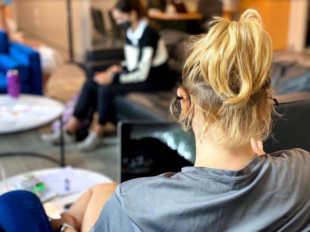 A youth with a pony tail seen from behind. 