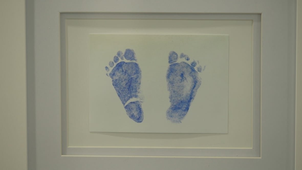 A blue set of baby footprints in a white frame.