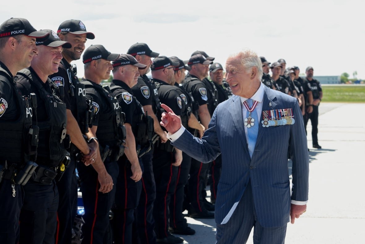 King Charles interacts with police officers while departing after a two-day visit in Ottawa on Tuesday, May 27, 2025.