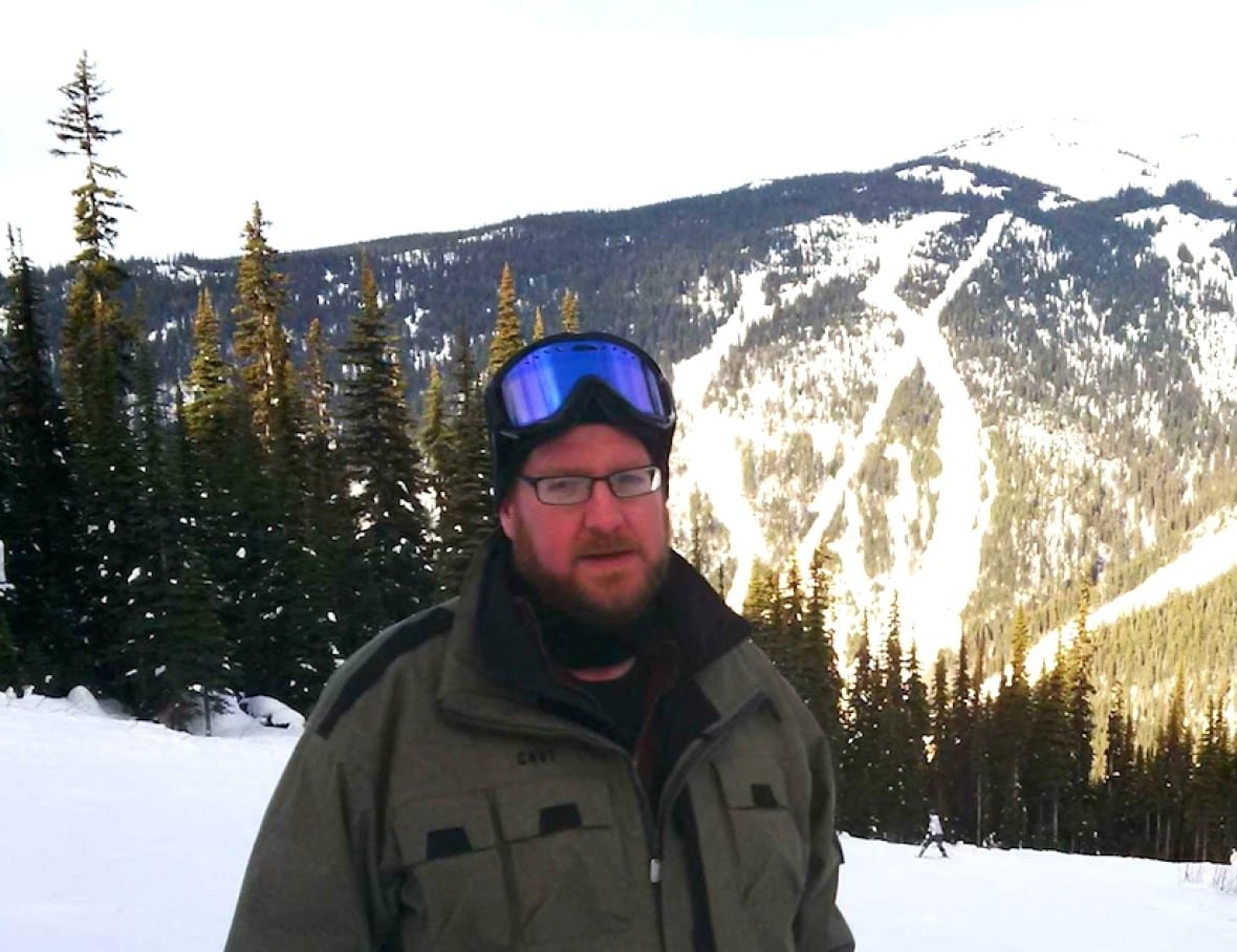 Man wearing ski goggles standing on a mountain