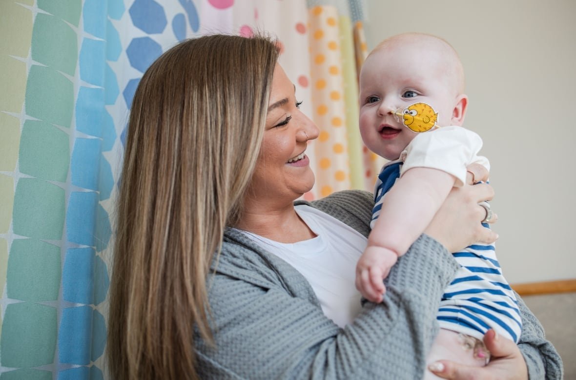 A mother holding a baby after a unique medical procedure.
