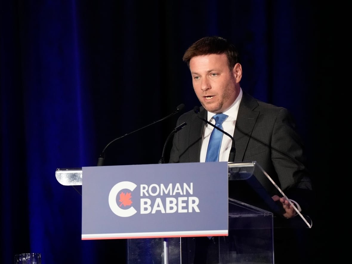 A man speaks into a microphone at a podium.