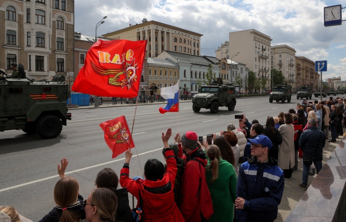Spectators watch a column of Russian armoured vehicles driving along a road on the day of a rehearsal for a military parade, which marks the 80th anniversary of the victory over Nazi Germany in World War Two, in Moscow, Russia, May 7, 2025. 