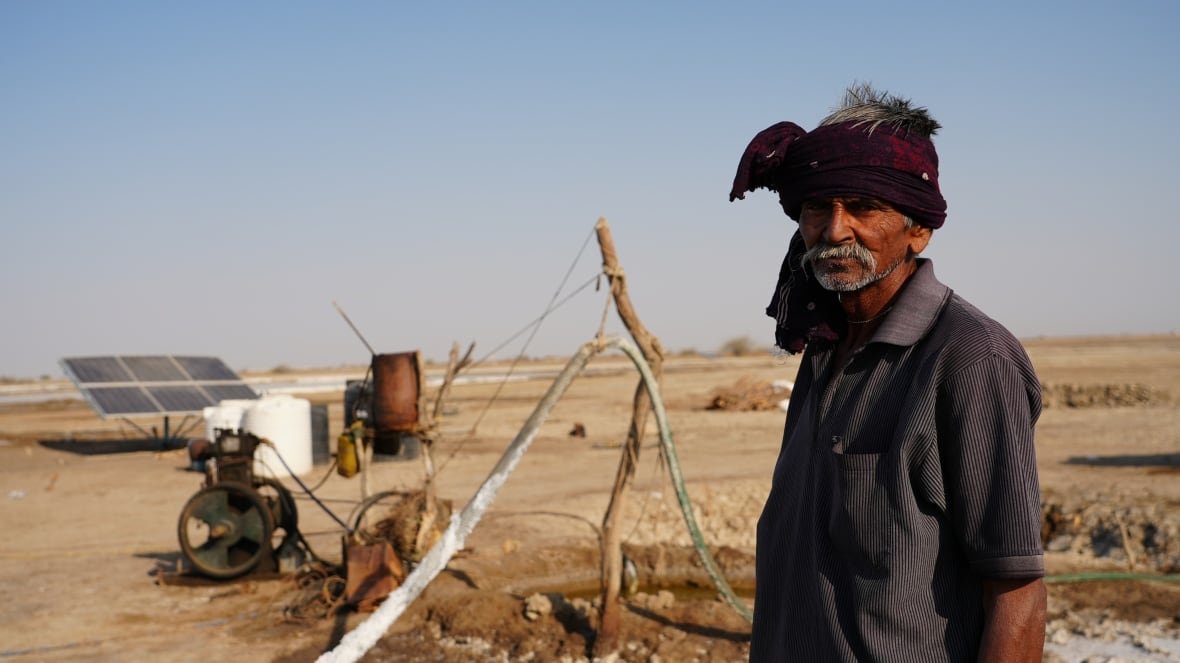 A person stands near an old machine.