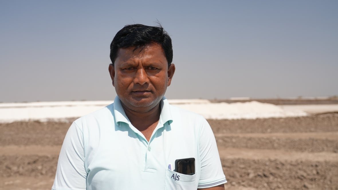 A person stands in a desert. 