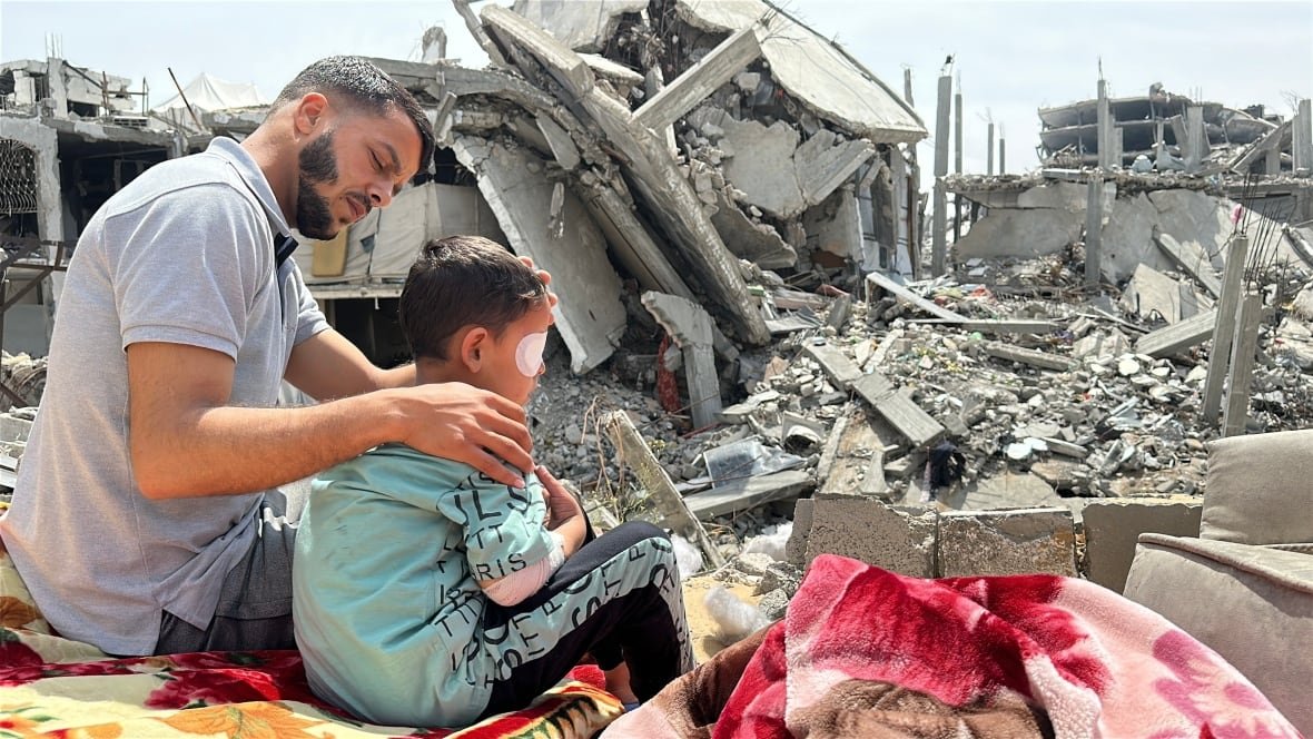 a man and his son sit in front of rubble