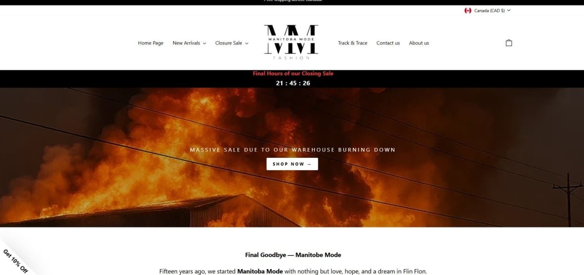 A website for a company called Manitoba Mode shows a photo of a massive fire at a building with two fire trucks sitting out front. No firefighters are seen fighting the blaze. On the screen it says massive sale due to our warehouse burning down.