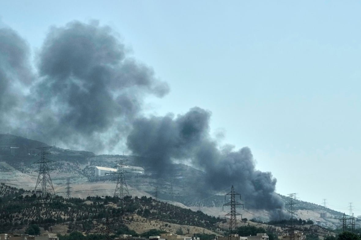 Smoke rises along a hillside