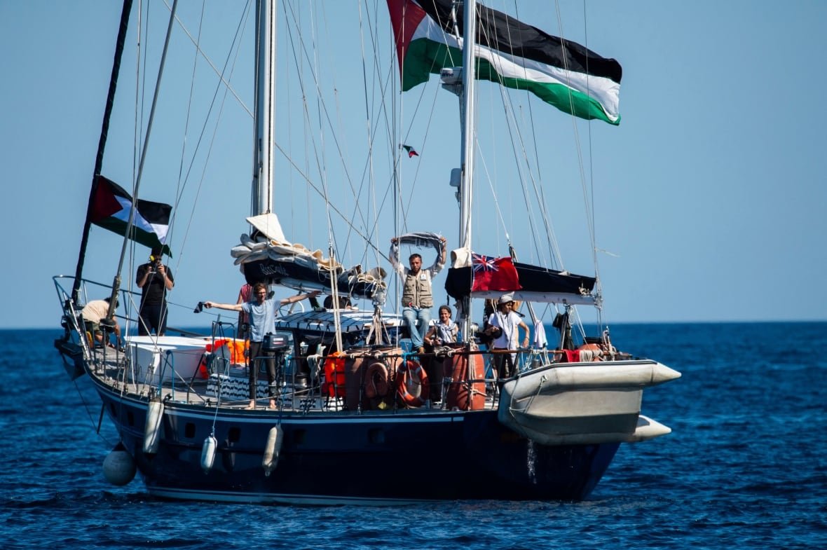 People pose for a photo aboard a ship in the water
