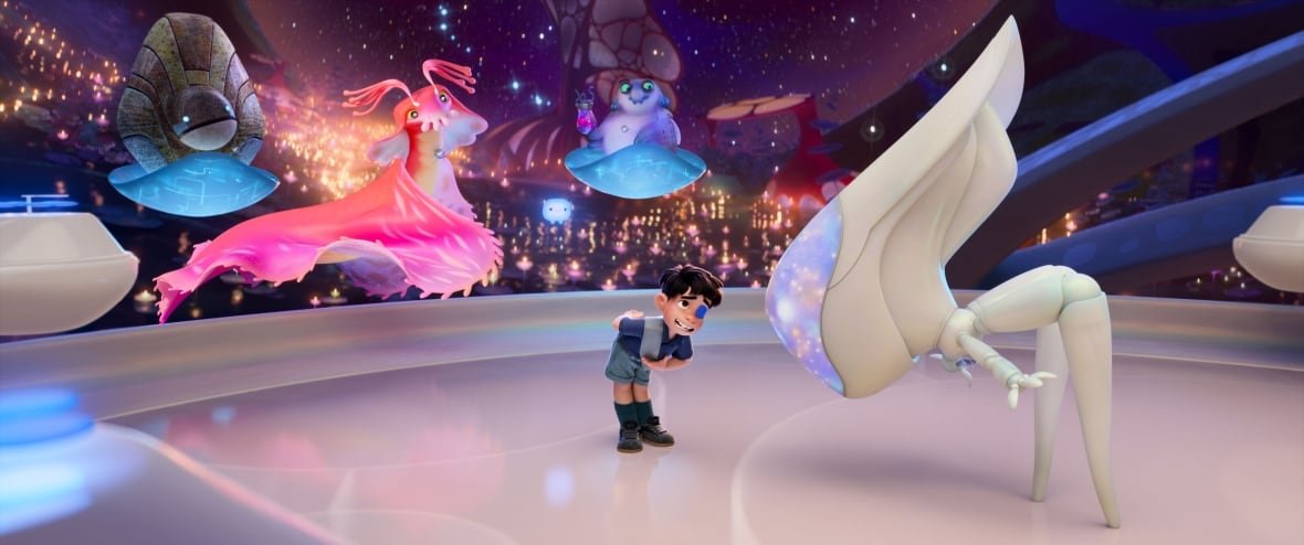 An animated image is shown. In it, a little boy standing on a platform boys in front of a robotic figure. Behind him are other aliens floating in the air.
