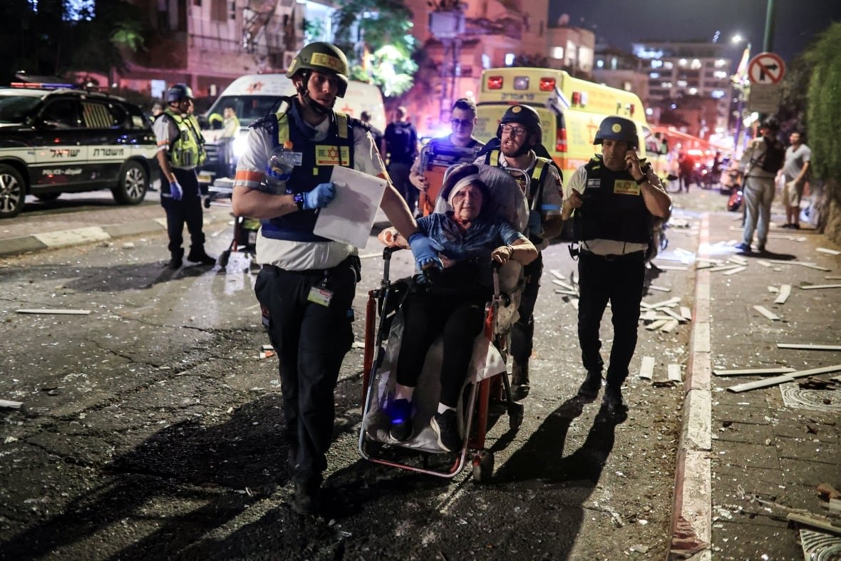 Rescue personnel evacuate a wounded woman at an impact site following missile attack from Iran on Israel, in Ramat Gan, Israel  June 13, 2025