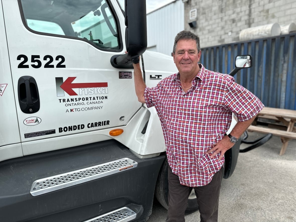 man in plaid shirt in front of white truck