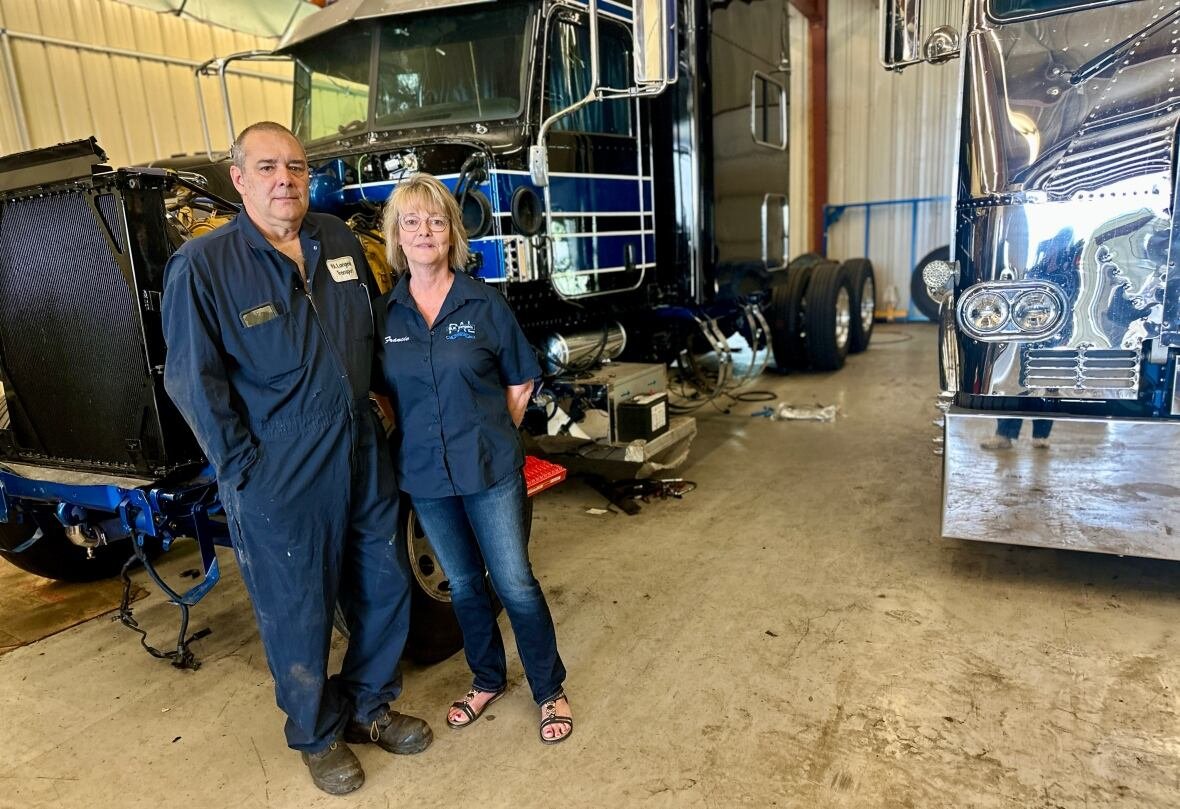 man and woman in navy blue in front of transport truck