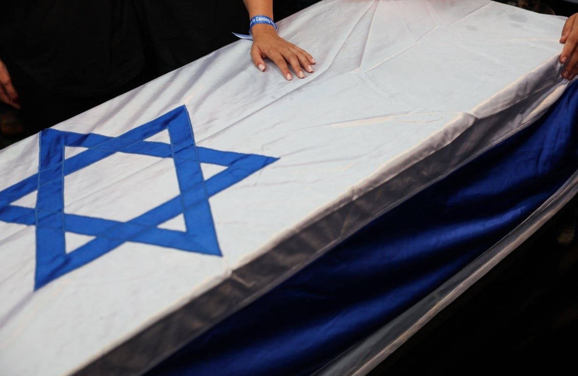 A person touches the coffin of Yonatan Samerano who was kidnapped during the deadly October 7, 2023, attack on Israel by Hamas and killed in Gaza, and whose body was recovered recently, during his funeral, in Tel Aviv, Israel June 24, 2025.
