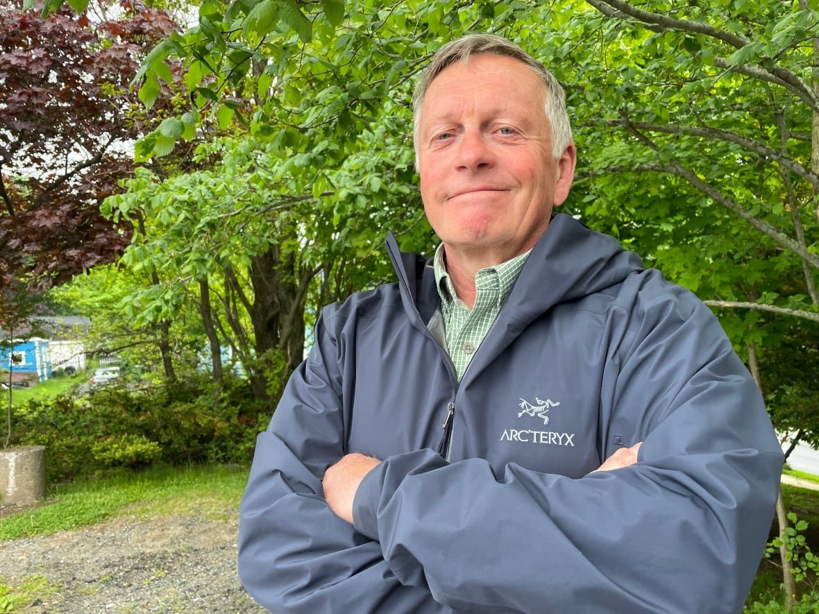 A man stands with his arms crossed posing for a picture.