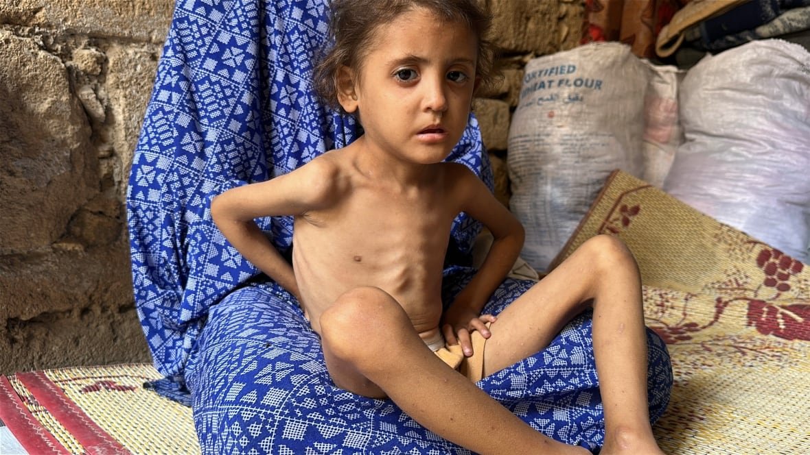 A young girl sits in her mother's lap.
