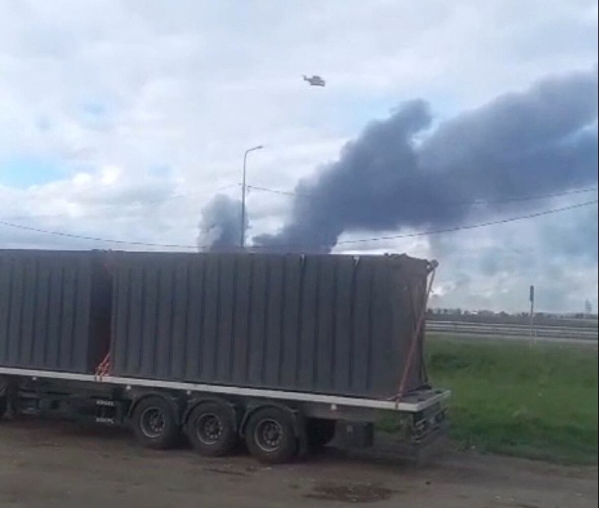 A drone lifts off from wooden sheds loaded onto a truck that was driven to the perimeter of an air base, as smoke rises in the background, in Mal'ta, Irkutsk Region, Russia.