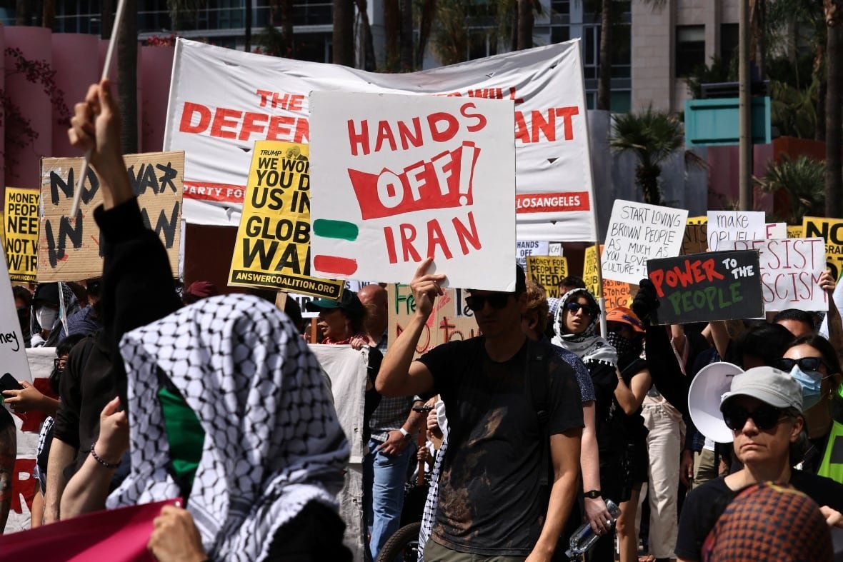 Protesters hold up signs during a rally.