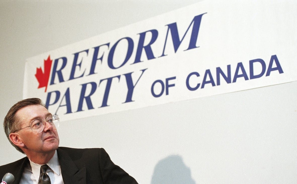 Preston Manning pauses in front of a Reform Party of Canada sign during a news conference in Ottawa on Nov. 27, 1991.