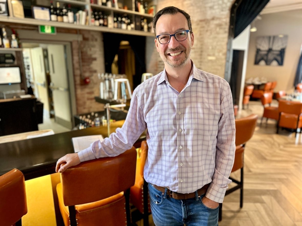 man in front of bar with glasses