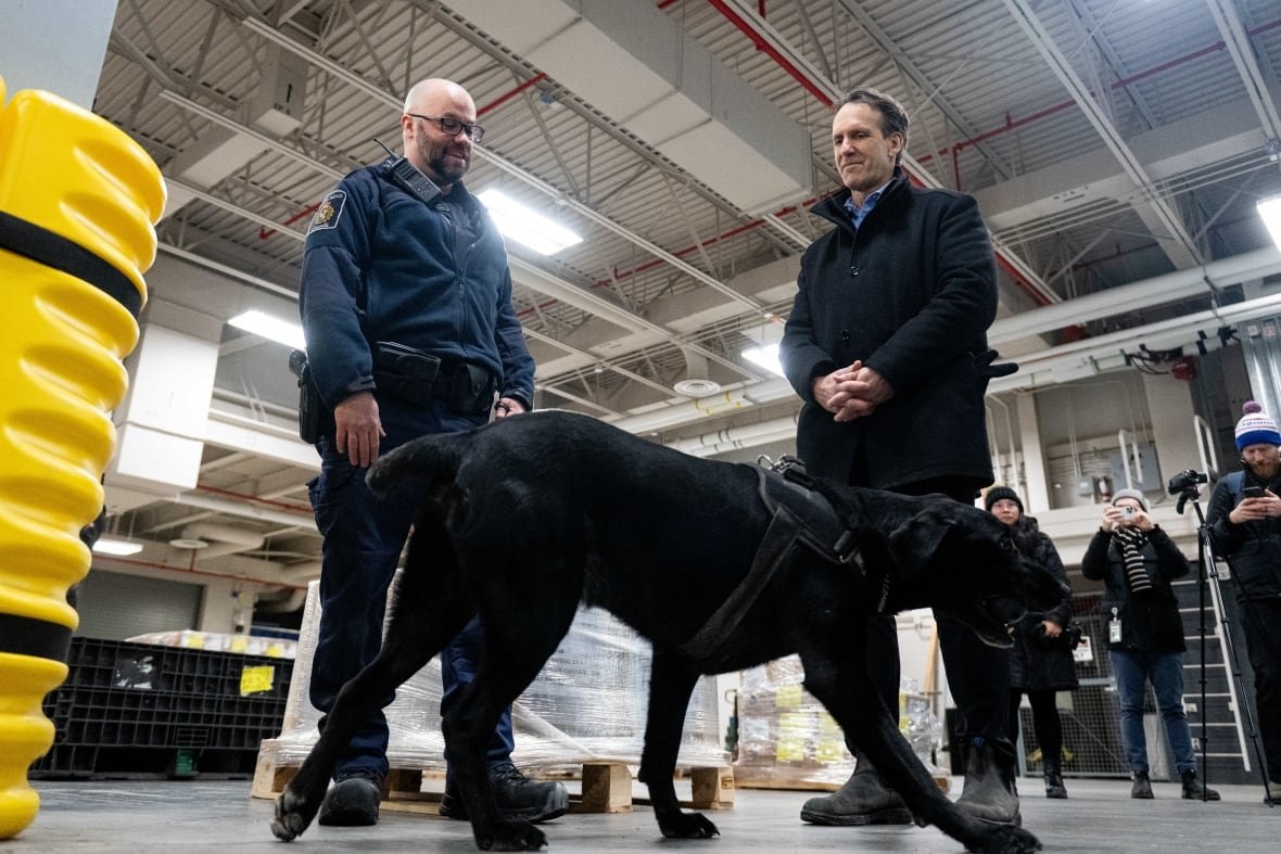 Canada's fentanyl czar Kevin Brosseau, right, is seen with Denver, a Canada Border Services Agency narcotics detection dog, during a tour of the CBSA Lansdowne port of entry in Lansdowne, Ont., on Wednesday, Feb. 12, 2025.