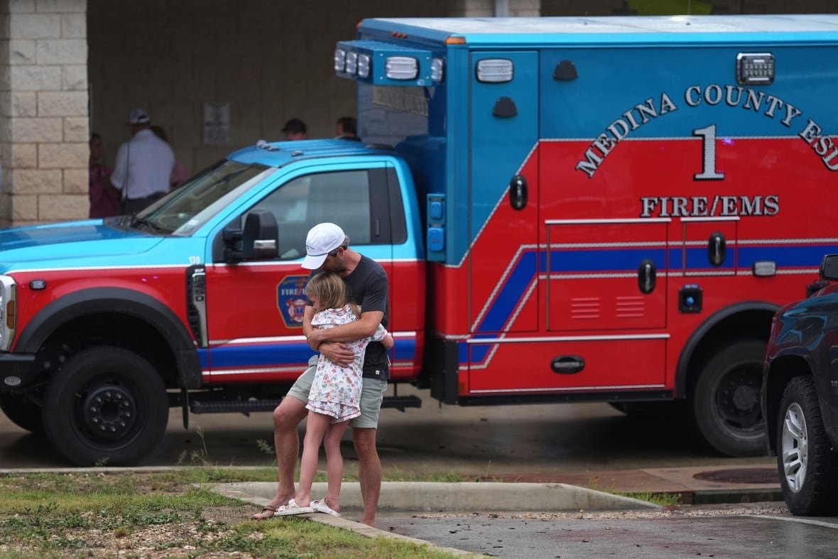 People are reunited at a reunification center after flash flooding.