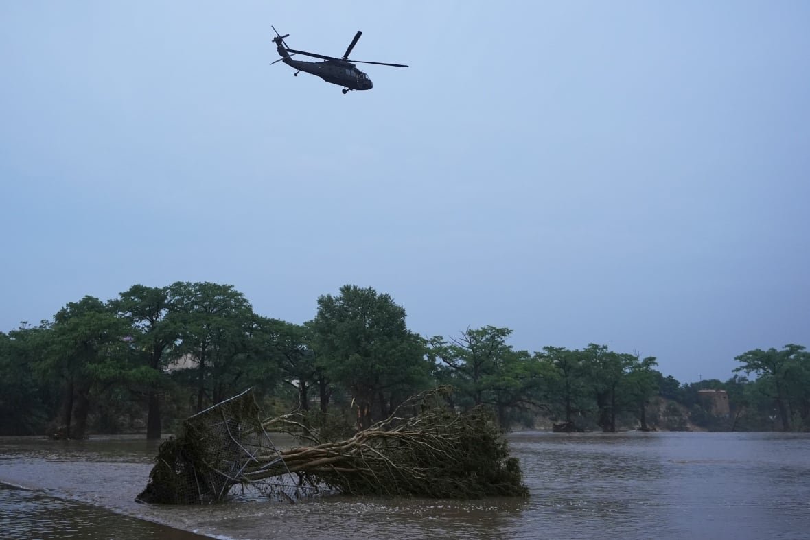 A helicopter flies over a river.