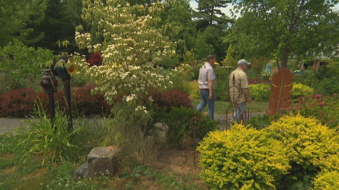 Tow men walk along a beautifully landscaped path