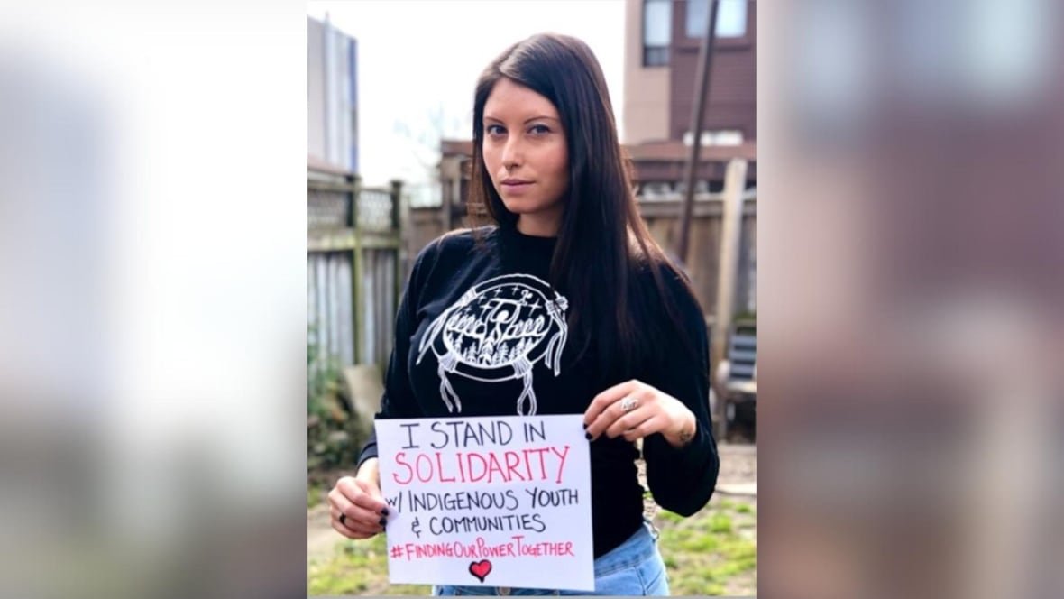 A person is seen holding a sign that says "I stand in solidarity with Indigenous youth and ciommunities #findingourpowertogether."